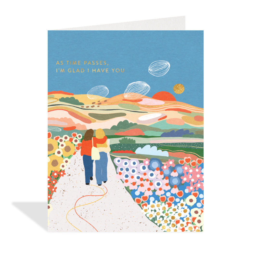 Greeting card designed by Marina Castaldo. A beautiful illustration of two people holding each other taking a stroll on a path around a lovely landscape. 