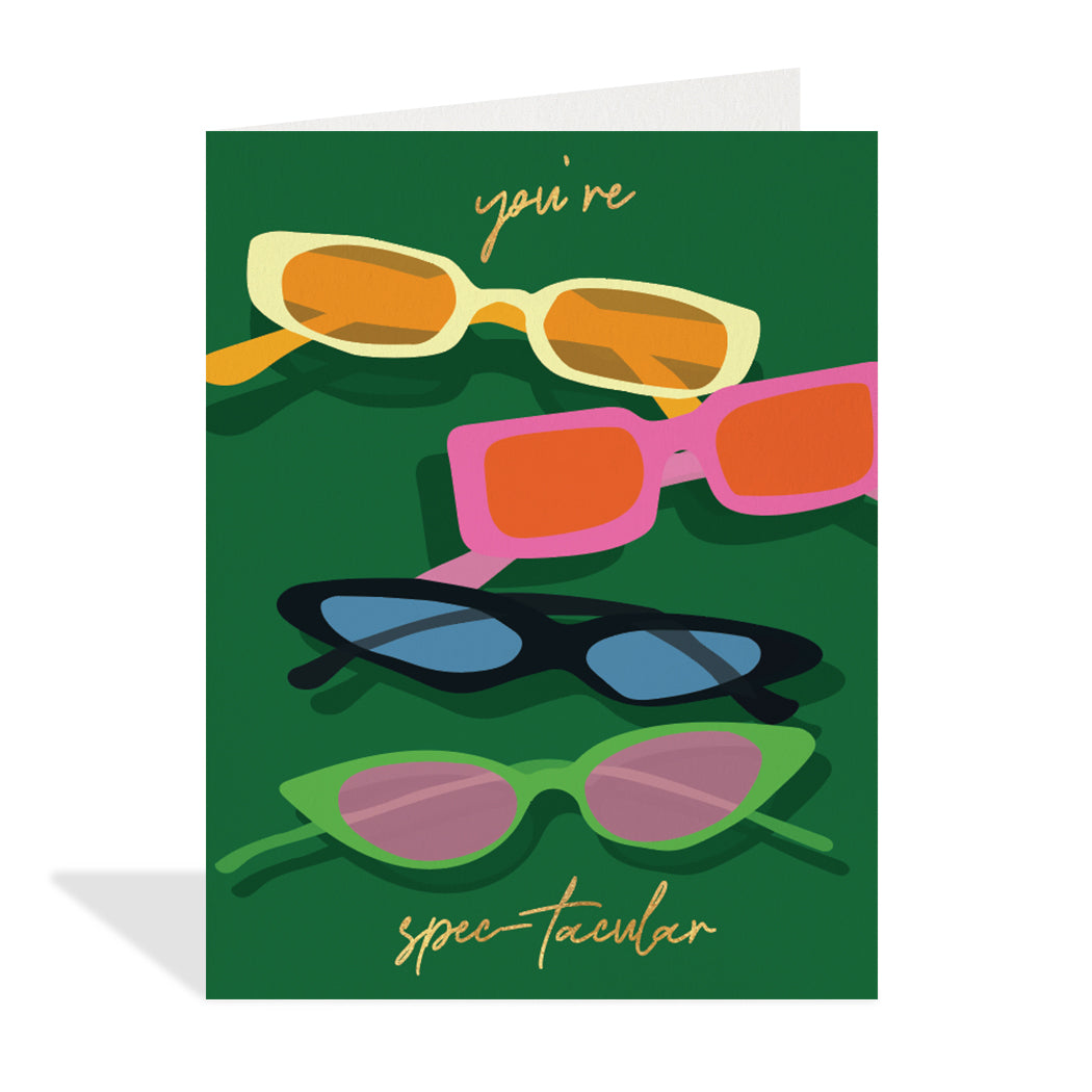 Greeting card design by Canadian Artist, Rachel Joanis. A cute illustration of  eye glasses both modern and retro inlcuding sunglasses with a gold foil sentiment that reads, "you're spectacular". 