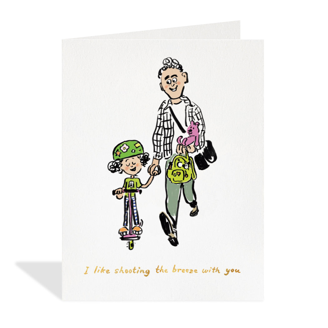 Greeting card design by Canadian Artist, Tine Modeweg-Hansen. A cute illustration of a dad holding his child's backpack, teddy bear and hand while the child is riding a pink scooter. A gold foil sentiment that reads "I like shooting the breeze with you".