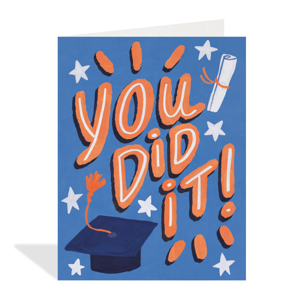 Greeting card design by Erin Mac. A cute illustration of a graduation cap and tassel with a diploma and stars in the background. A large red bubble-lettered sentiment that reads "You did it!".  
