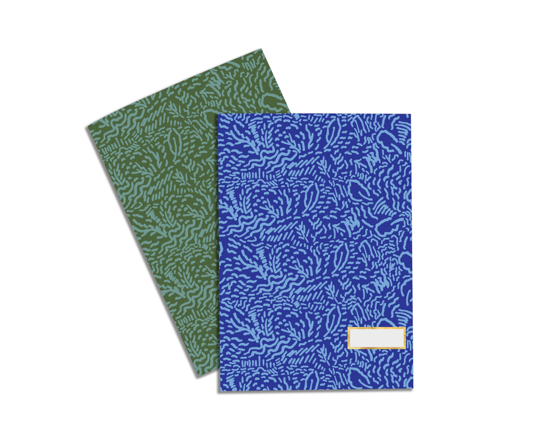 Illustrated Notebook Set by Atelier Mave with both notebooks styled in a vintage pattern, one being blue and one being green.