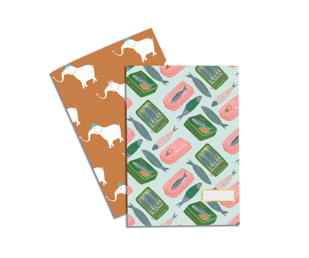 Illustrated Notebook Set by Atelier Mave with one design being a fun display of  anchovies and tins in green and pink and the other design being a fun elephant pattern where the elephants are wearing tiny hats. 