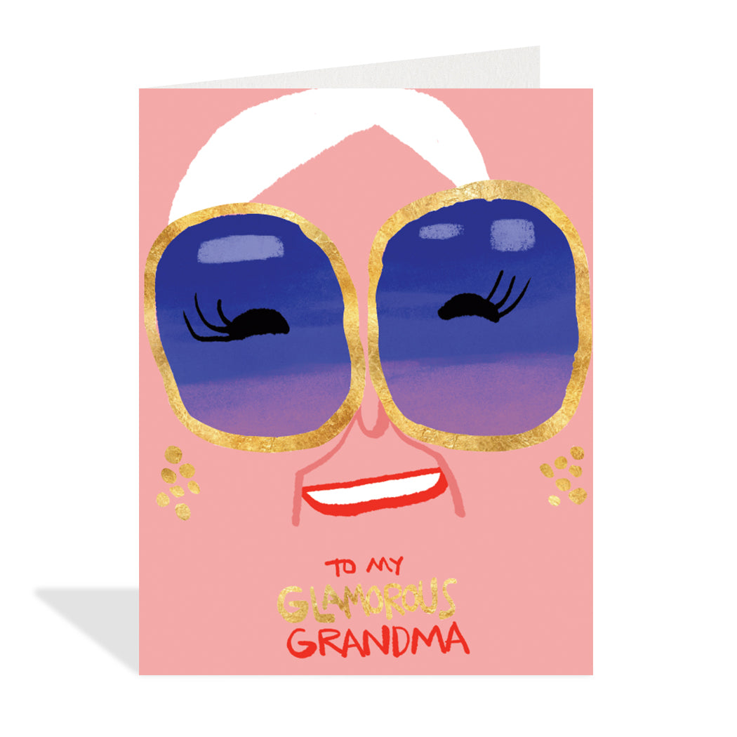 Greeting card design by Carlos Aponte. A charming illustration of a grandma's face with large gold foil sunglasses and earrings. A gold foil sentiment that reads "to my glamorous grandma".