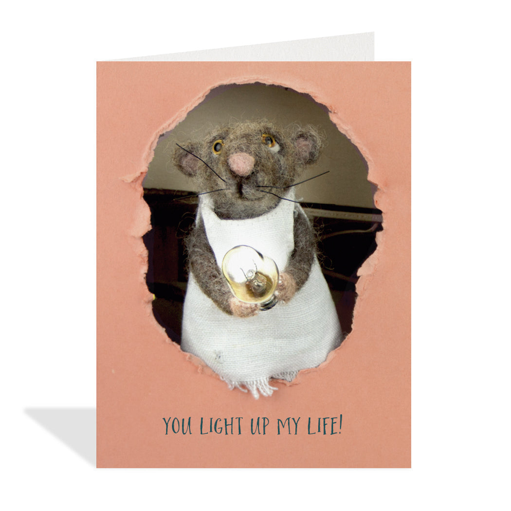 Greeting card design created by Canadian artist, Claudine Crangle. A cute image of a felted mouse holding a lit lightbulb with a sentiment that reads "you light up my life".