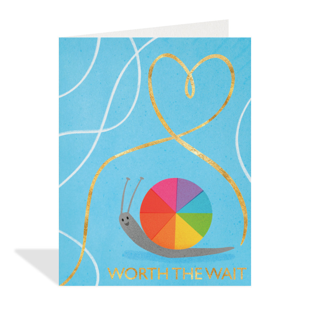 Greeting card designed by Alys Paterson. A cute snail with a rainbow shell and a gold heart above with a sentiment that reads "worth the wait".