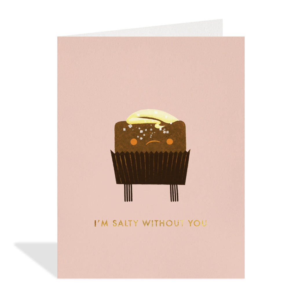 Greeting card design by Kath Waxman. A salted chocolate truffle on a pink background with a gold foil sentiment that reads "I'm salty without you".