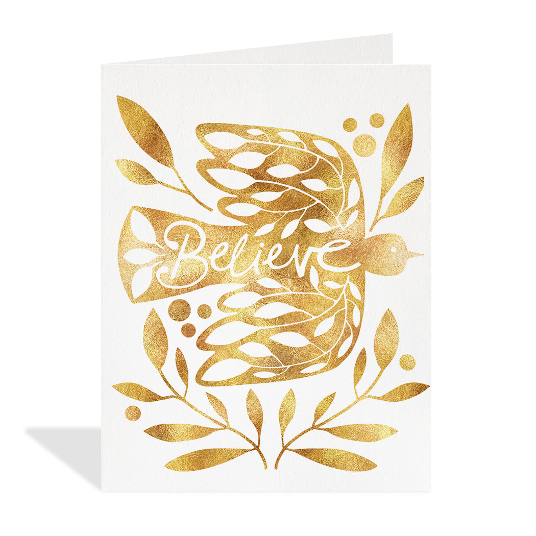 Greeting card illustration by Hannah Beisang. Illustration of a gold foil dove with surrounding floral designs. Typography that reads "believe" in the negative space of the bird